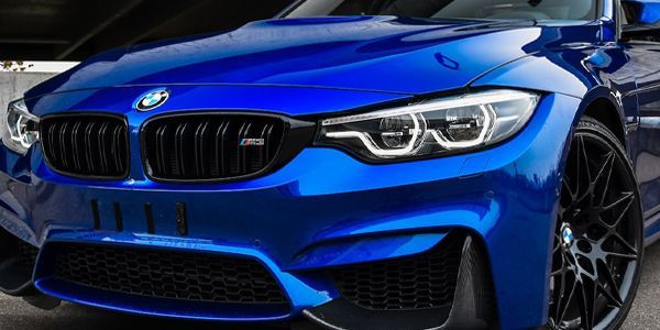 A blue bmw m3 is parked in a parking lot.