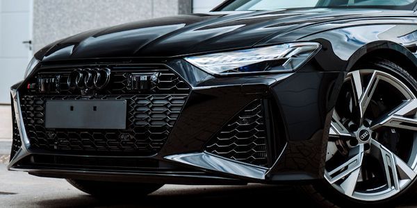 A black audi rs7 is parked in front of a garage.