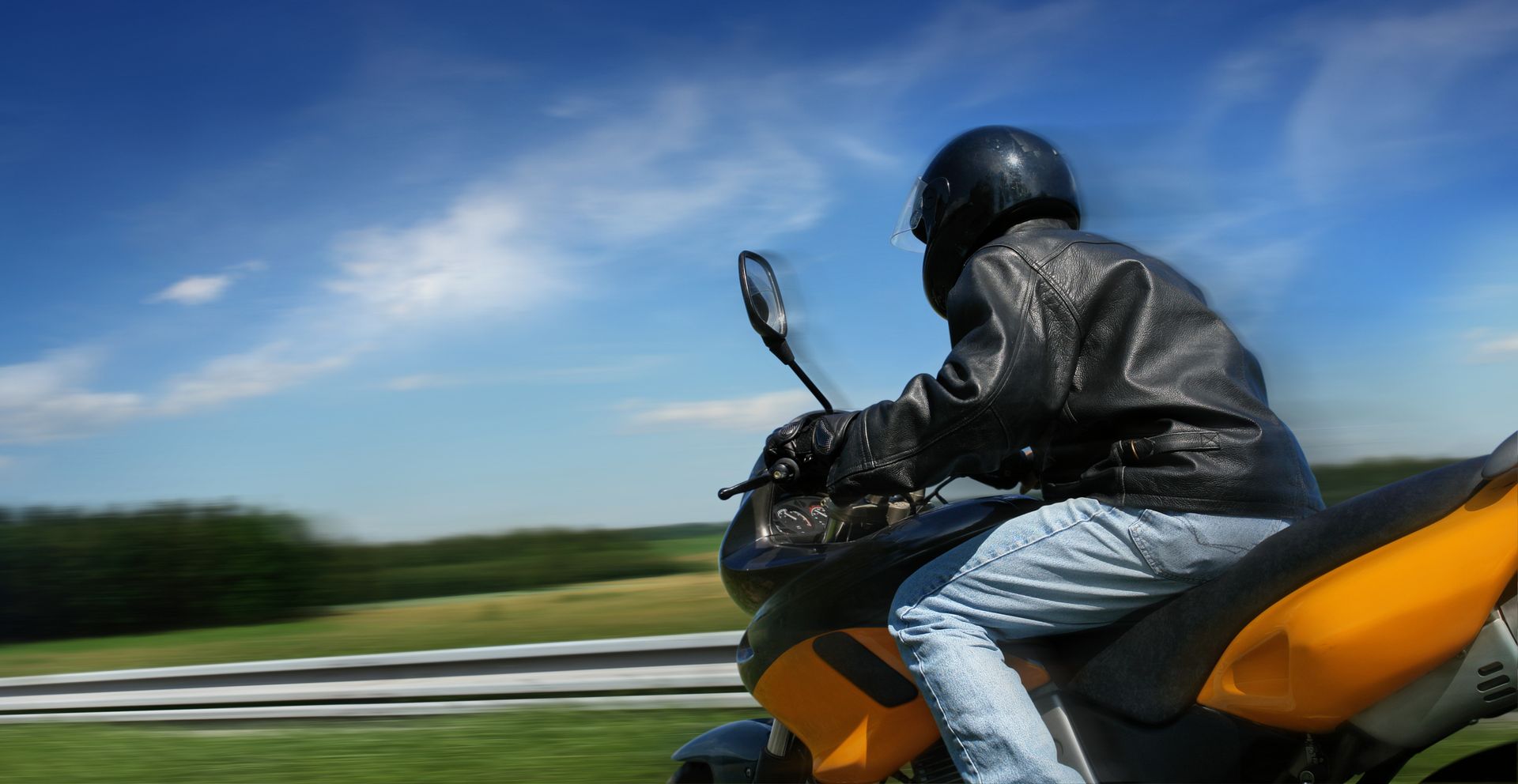 Person riding a motorcycle on a road with a blurred background. Person riding a motorcycle on a road with a blurred background.