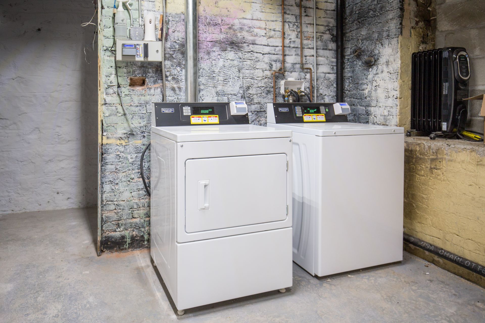 A washer and dryer are sitting next to each other in a basement.