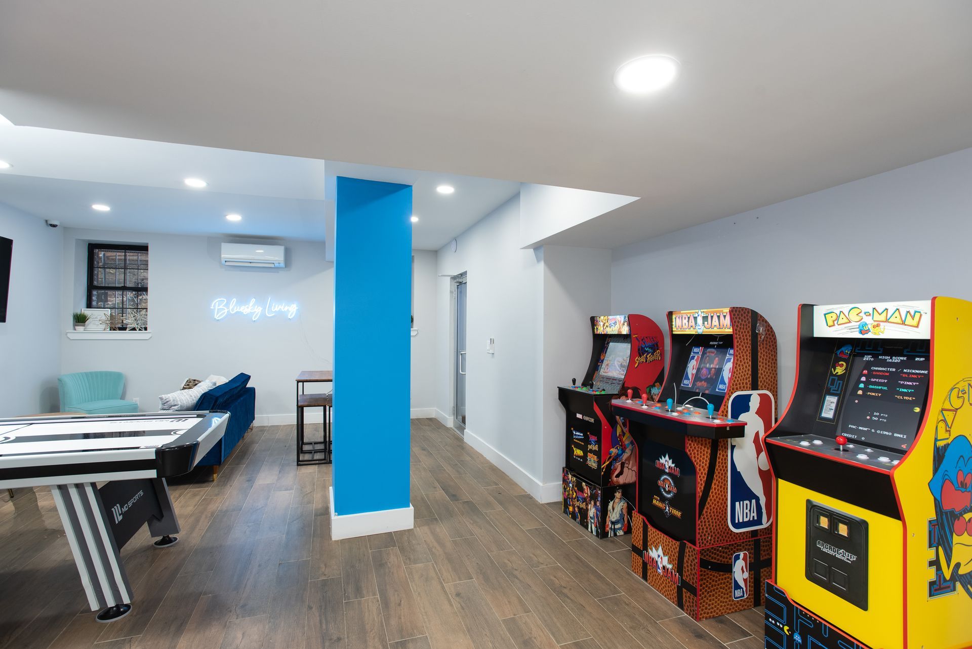 A game room with a pool table and arcade games.