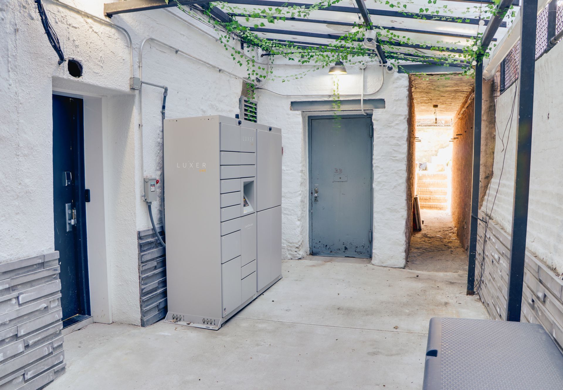 A hallway with a gray cabinet in the middle of it
