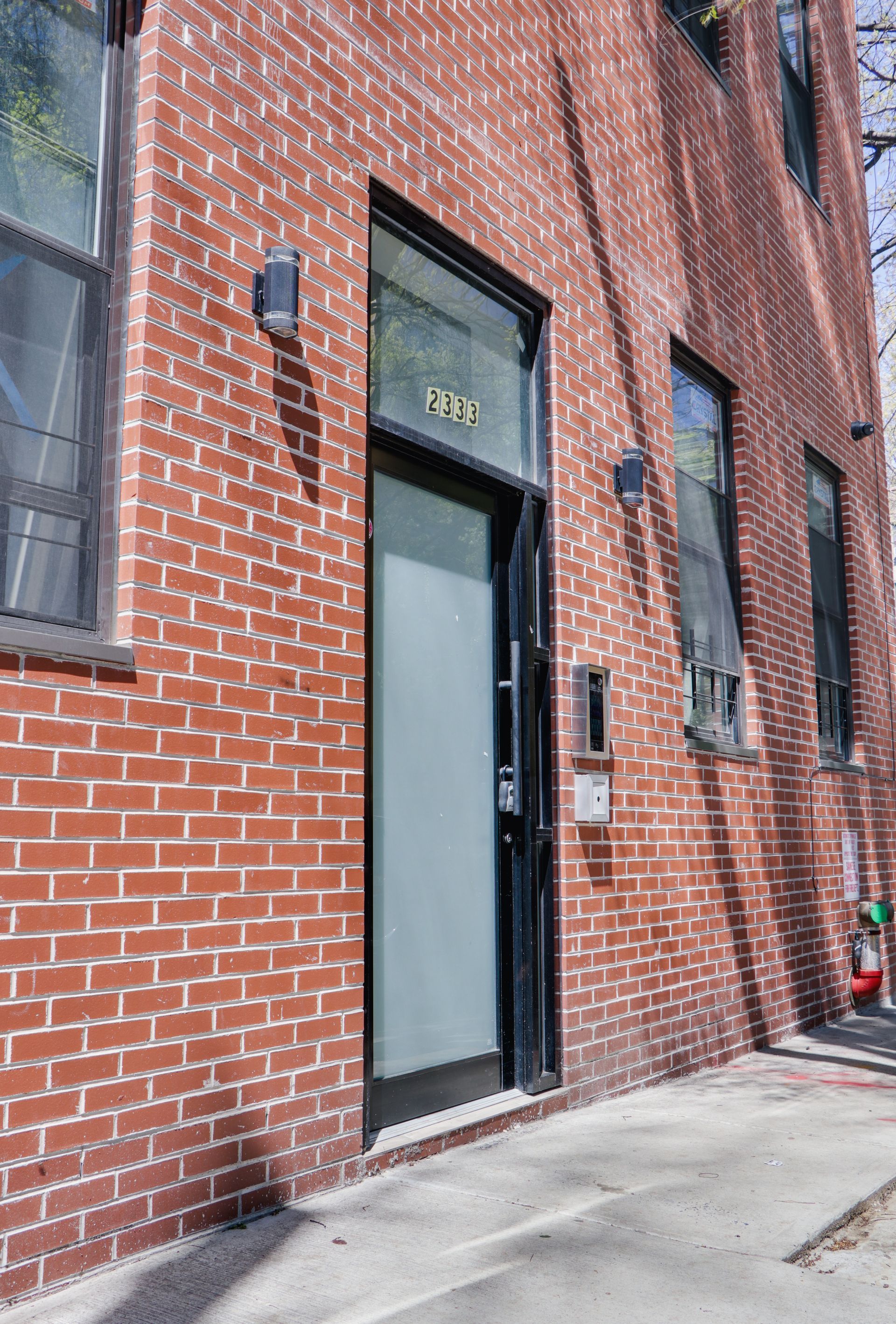 A red brick building with a black door and windows.