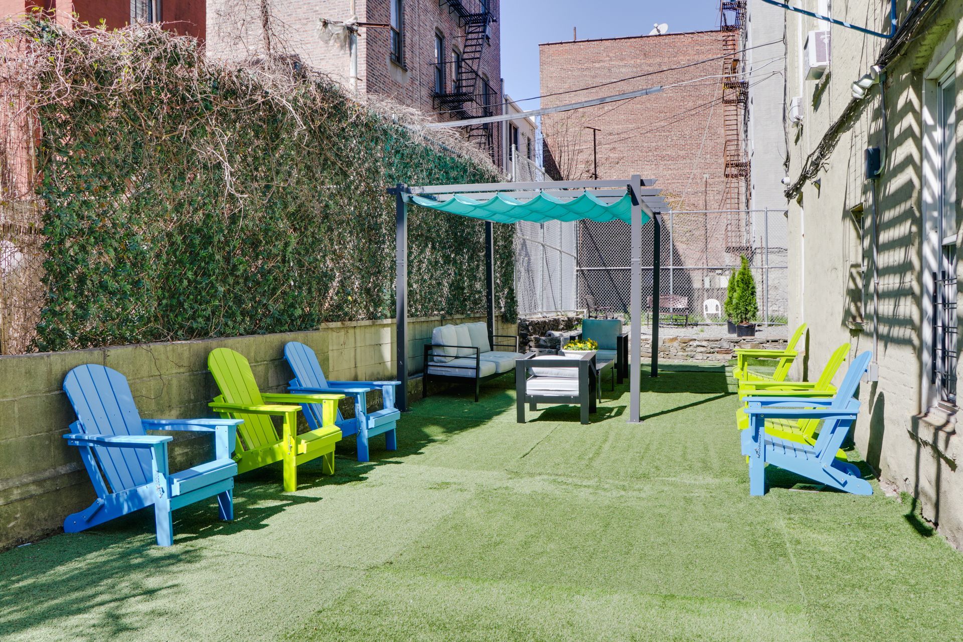 A row of colorful chairs are sitting on top of a lush green lawn.