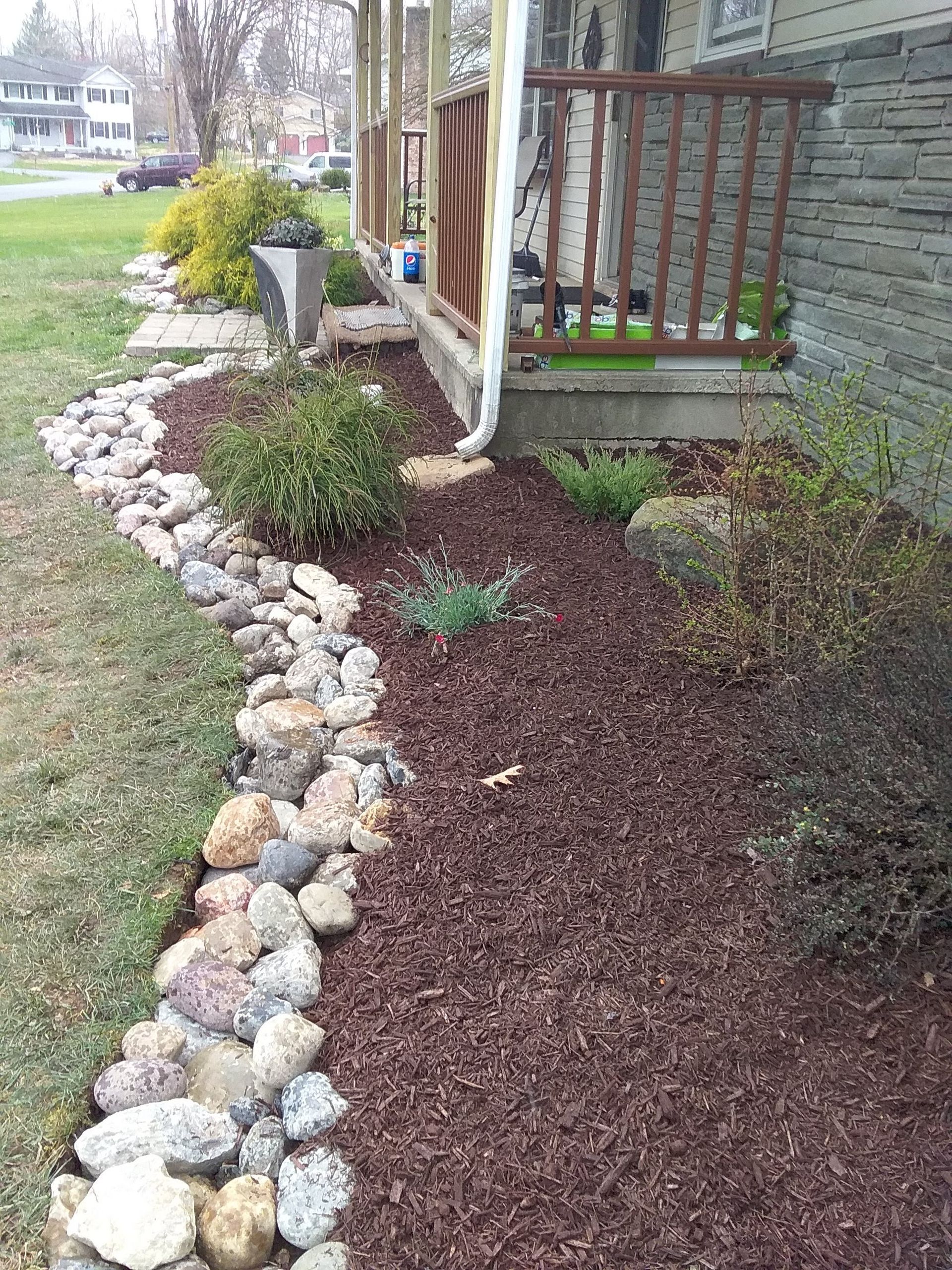 a stone walkway leading to a porch of a house .