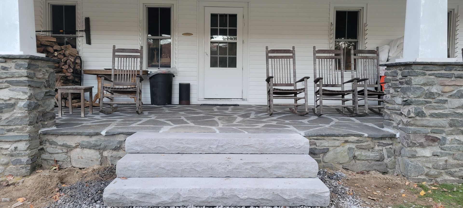 there are rocking chairs on the porch of a house .