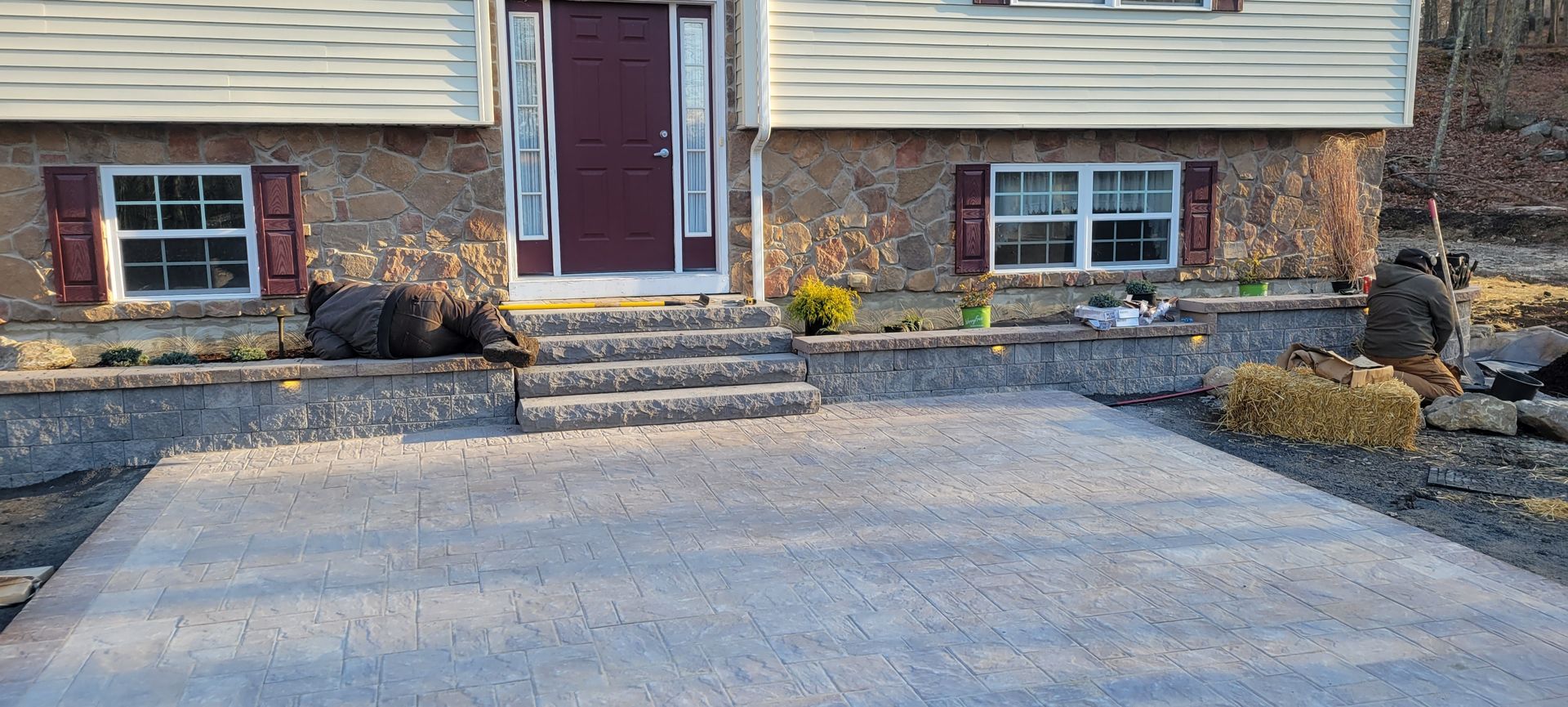 a brick house with a concrete driveway and staircase in front of it .
