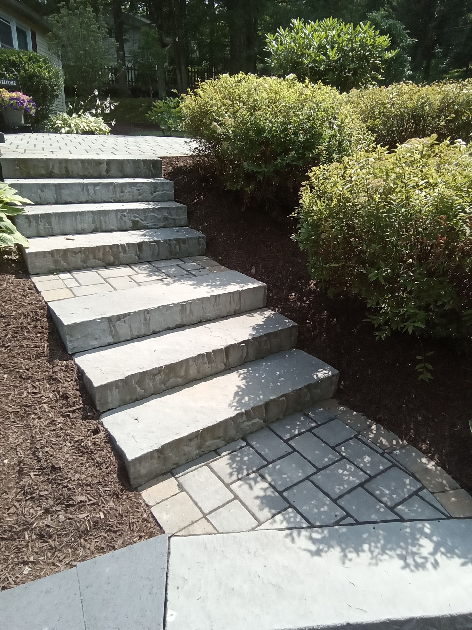 a set of stone stairs next to a stone wall created by A.A.F Landscaping