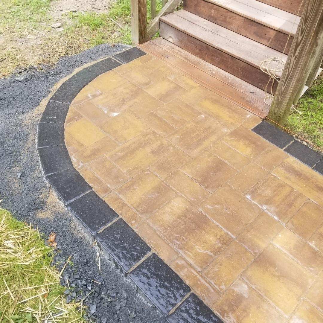 a brick walkway next to a set of stairs .
