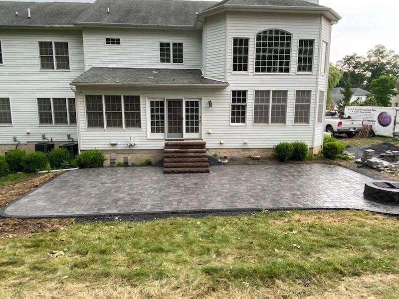 A large white house with a patio in front of it.
