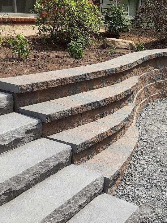 a set of stairs leading up to a stone wall .