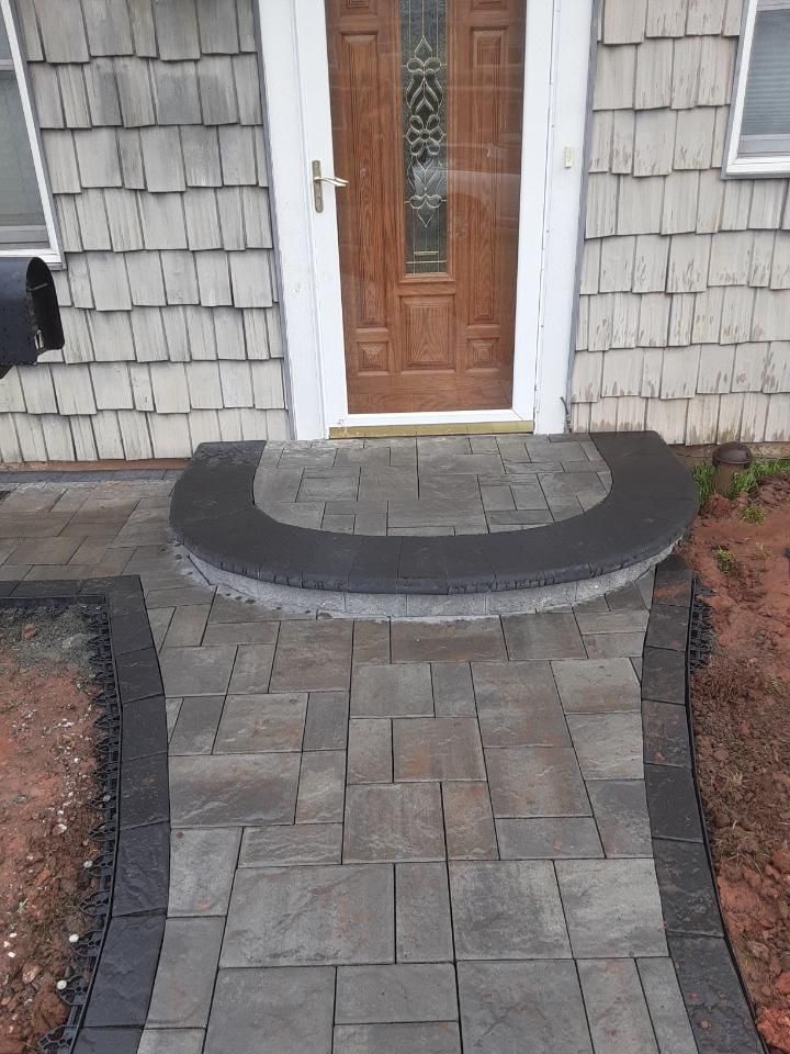 A brick walkway leading to the front door of a house.