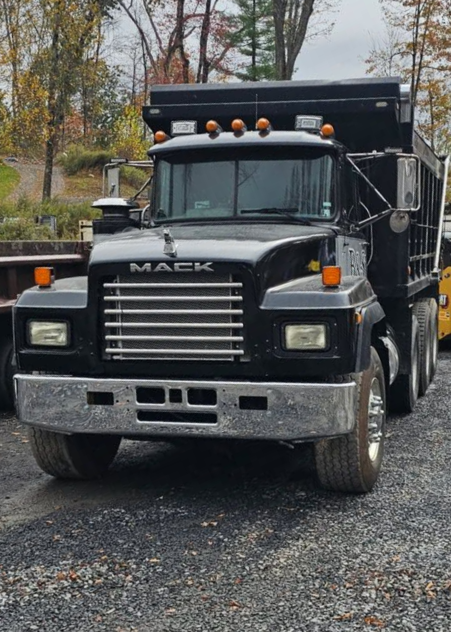 Black Mack dump truck parked on gravel.