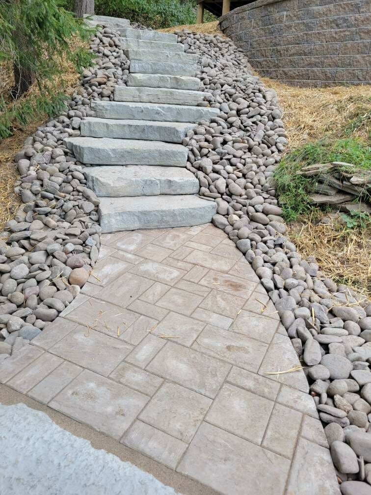 A set of stairs leading up to a stone wall.