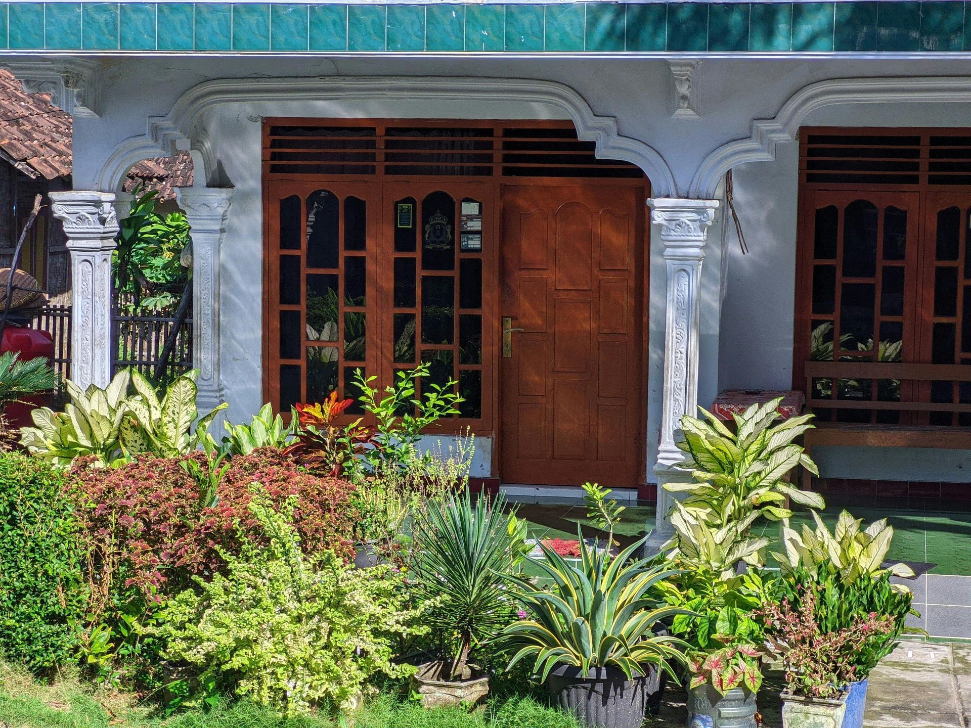 A house with a lot of potted plants in front of it