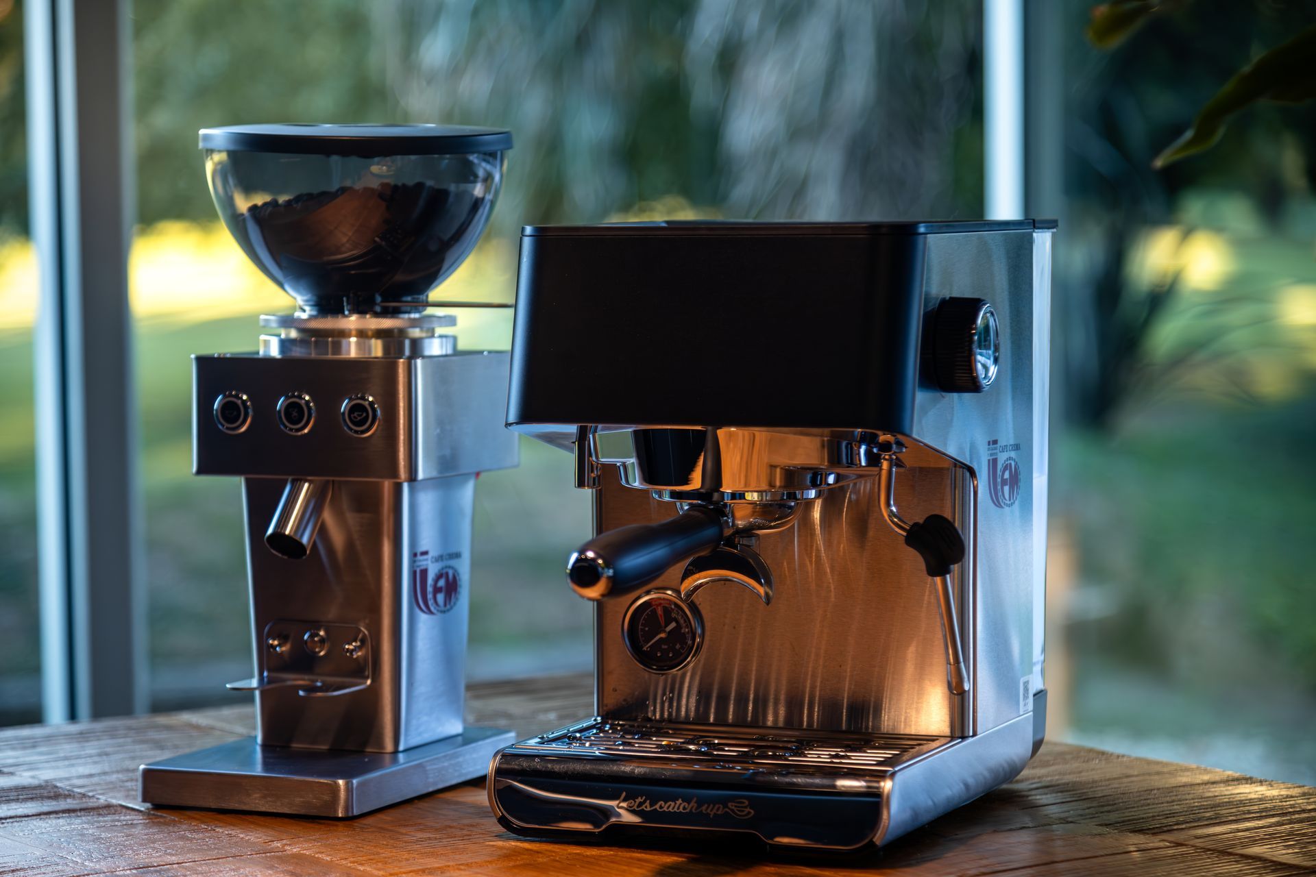 Dos cafeteras de acero inoxidable sobre una encimera de madera junto a una ventana,
