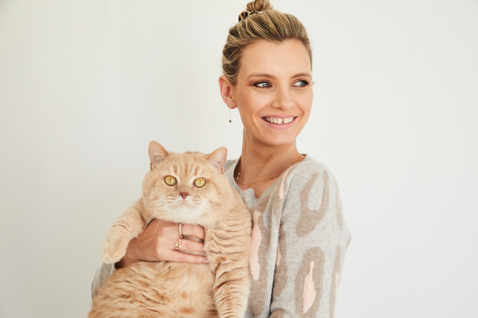 Ruth Crilly is holding her cat in her arms and smiling.