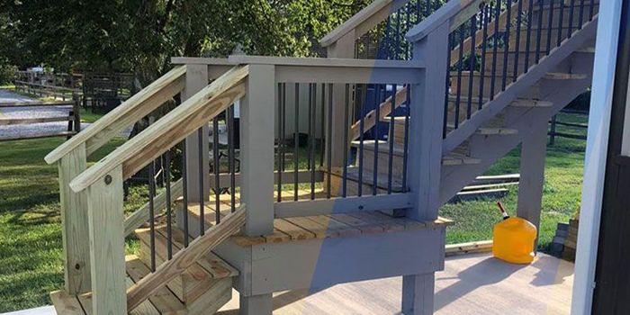A wooden deck with stairs being painted gray.