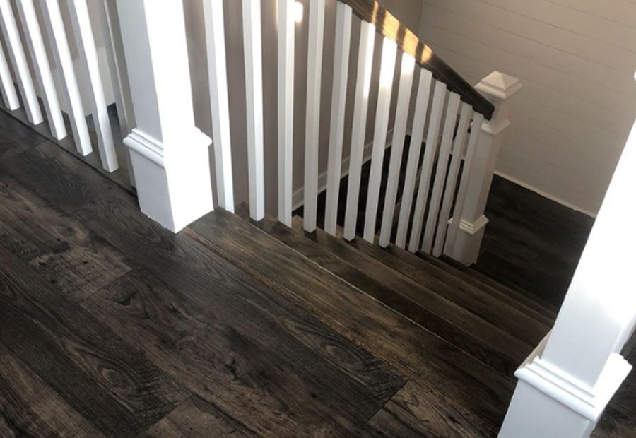 A staircase with a wooden floor and white railing.