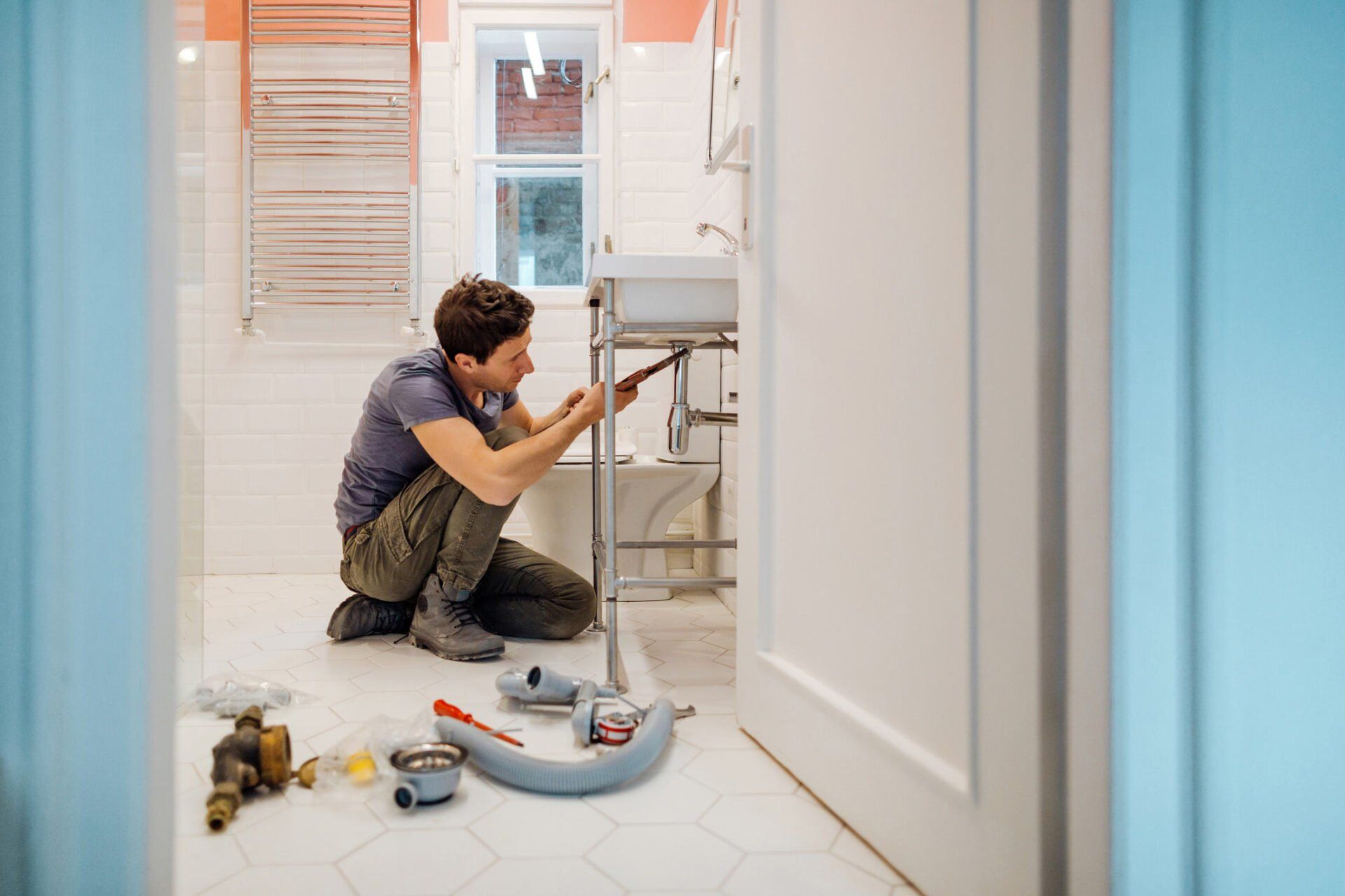 Man Fixing A Leak Under the Sink – Melbourne, VIC – Catco Plumbing