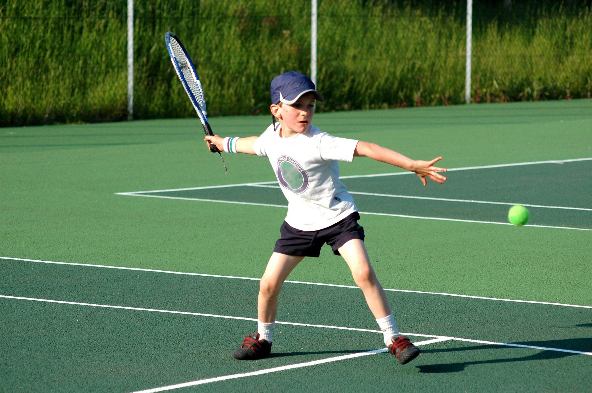 boy playing tennis outdoors