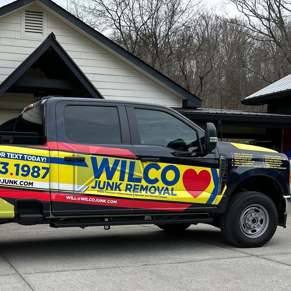 A wilco junk removal truck is parked in front of a house
