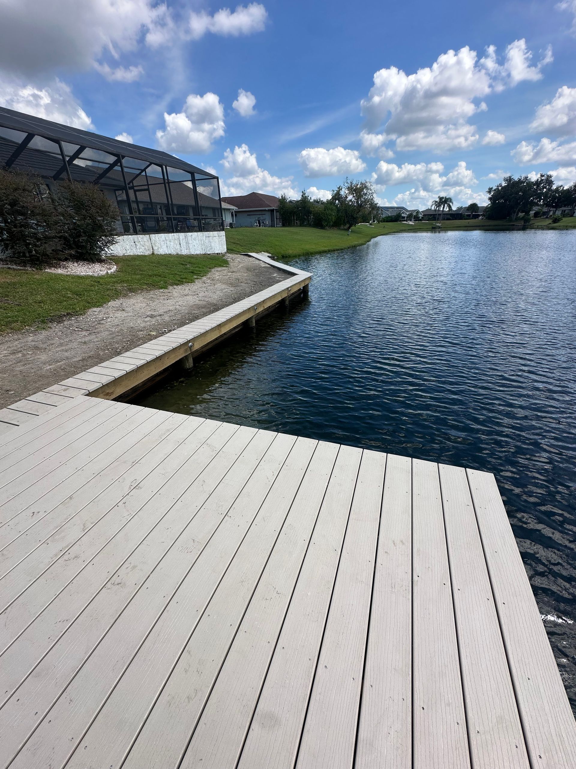 Wooden dock extending into a lake under a cloudy sky.