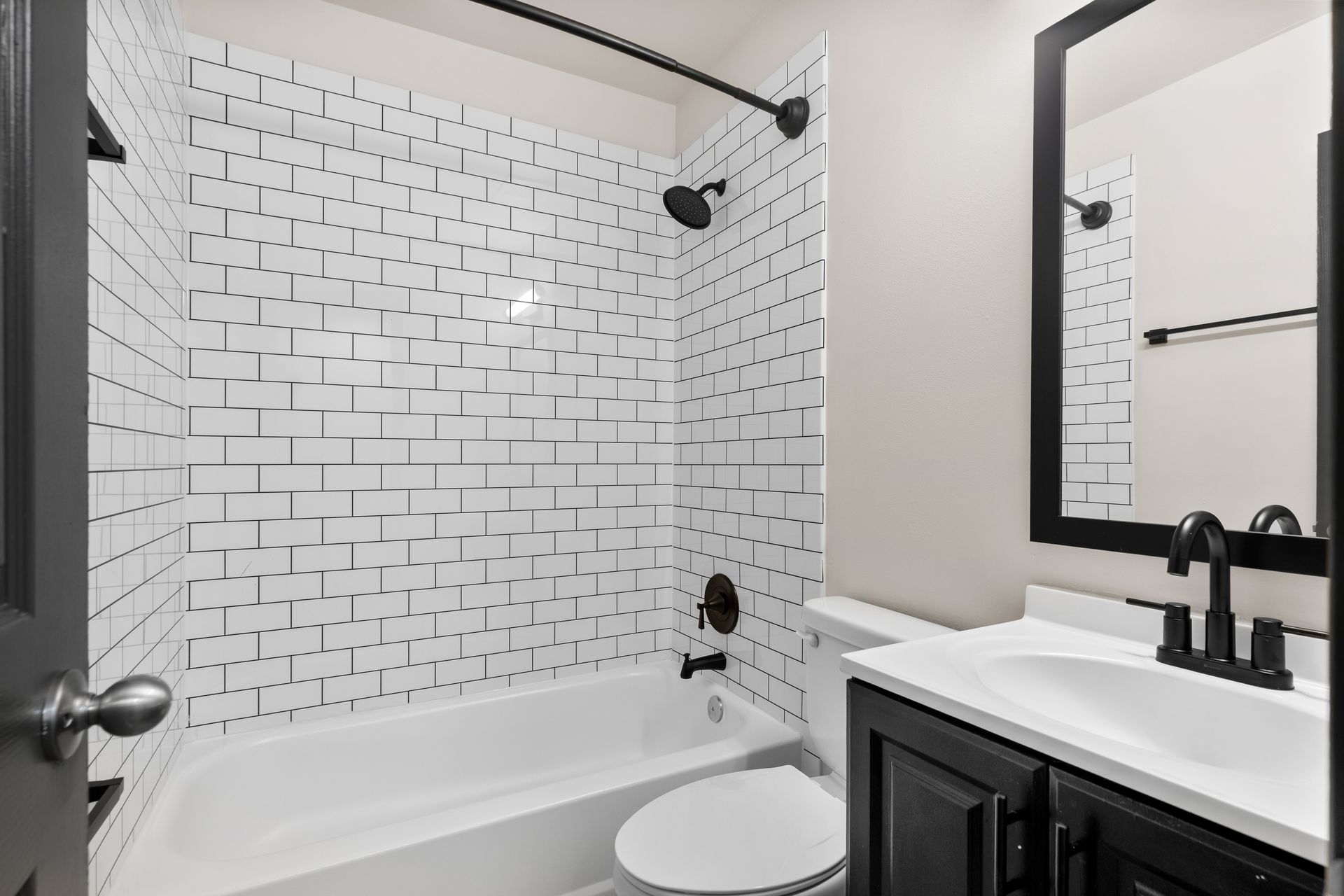 Modern bathroom with white subway tile shower, tub, vanity, and large mirror