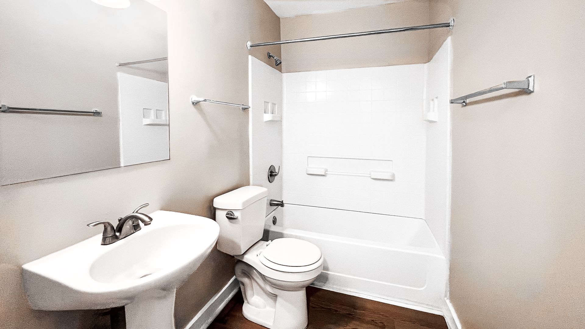 Bright white bathroom with sink, toilet, shower curtain, and bathtub against tiled walls.