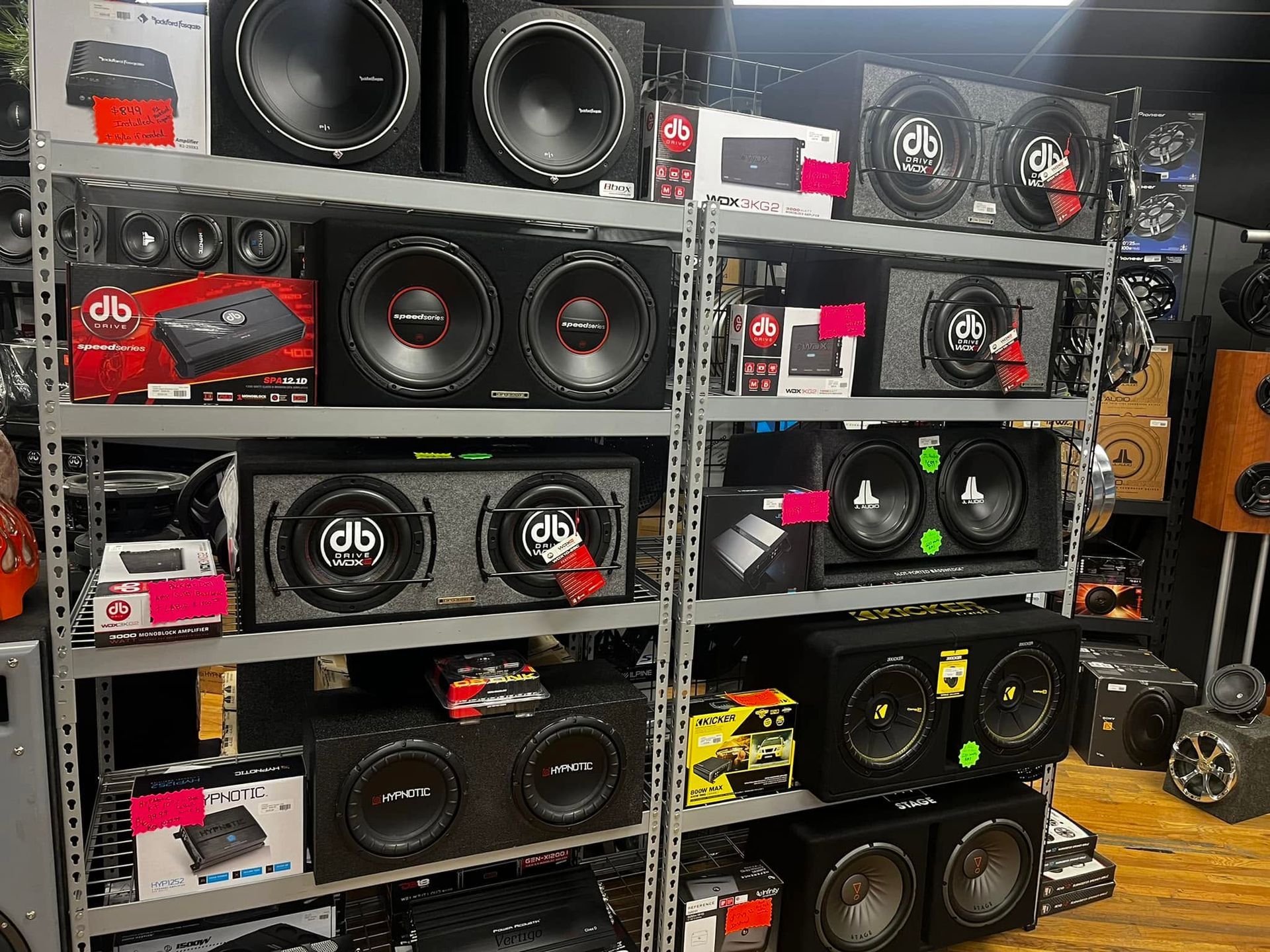 Shelves of car subwoofers and speakers in retail packaging in a store aisle