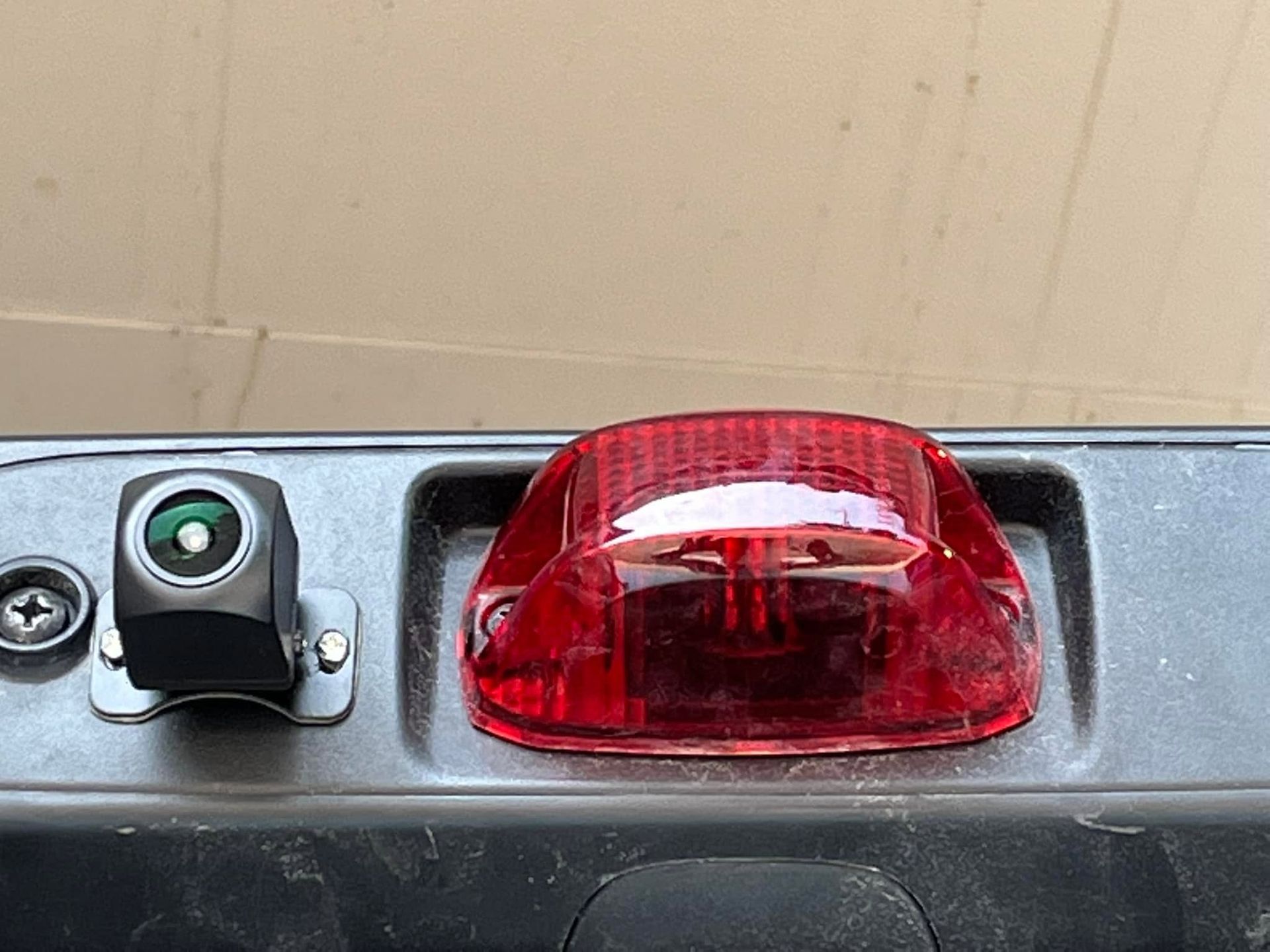 Red warning light and a small black switch mounted on a metal panel.