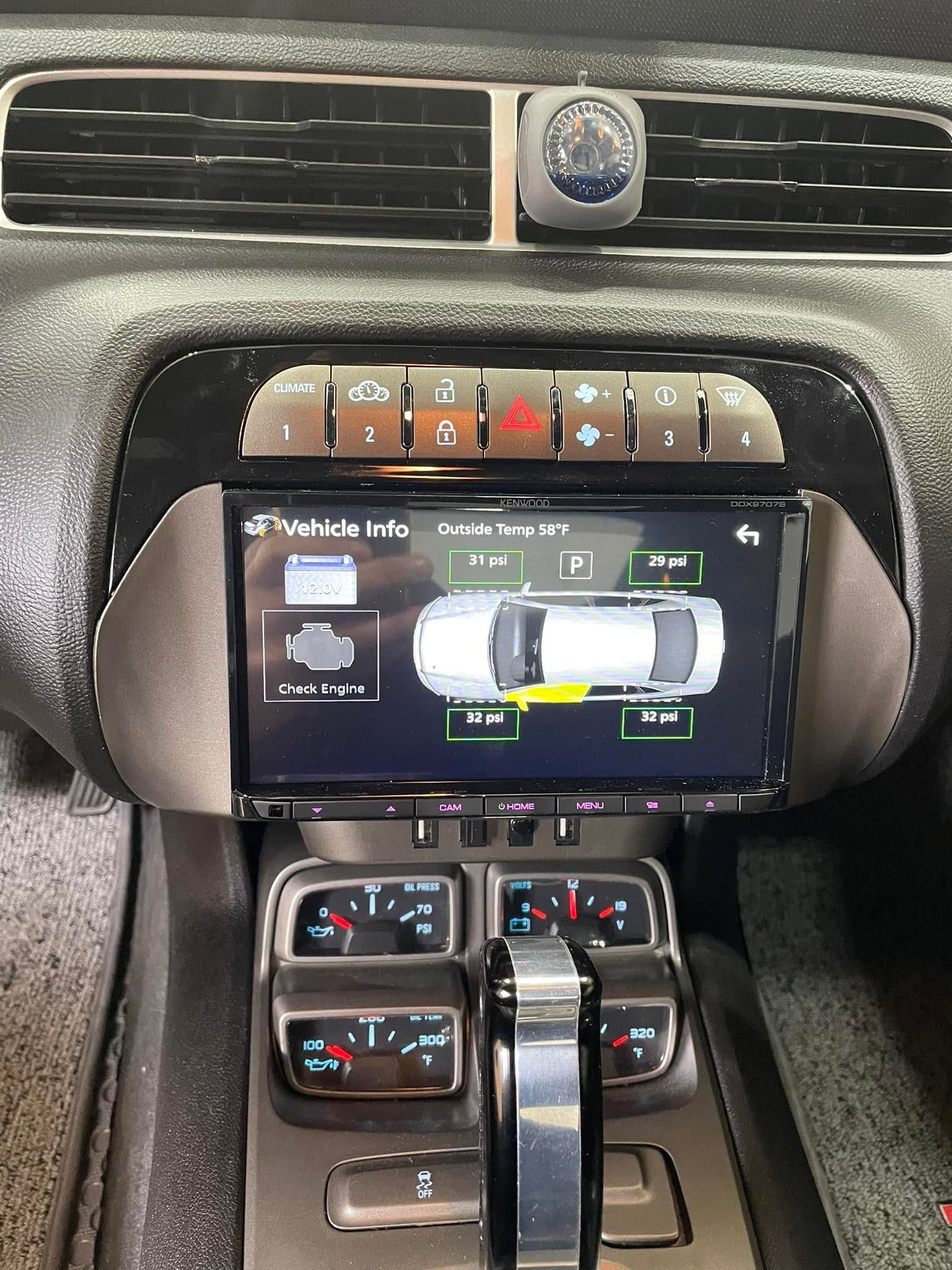 Car dashboard with central touchscreen and climate controls beneath air vents.