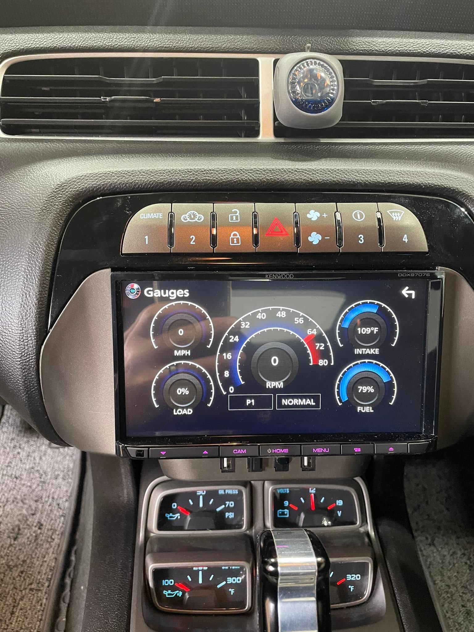 Car dashboard with center touchscreen showing climate controls and audio system beneath air vents