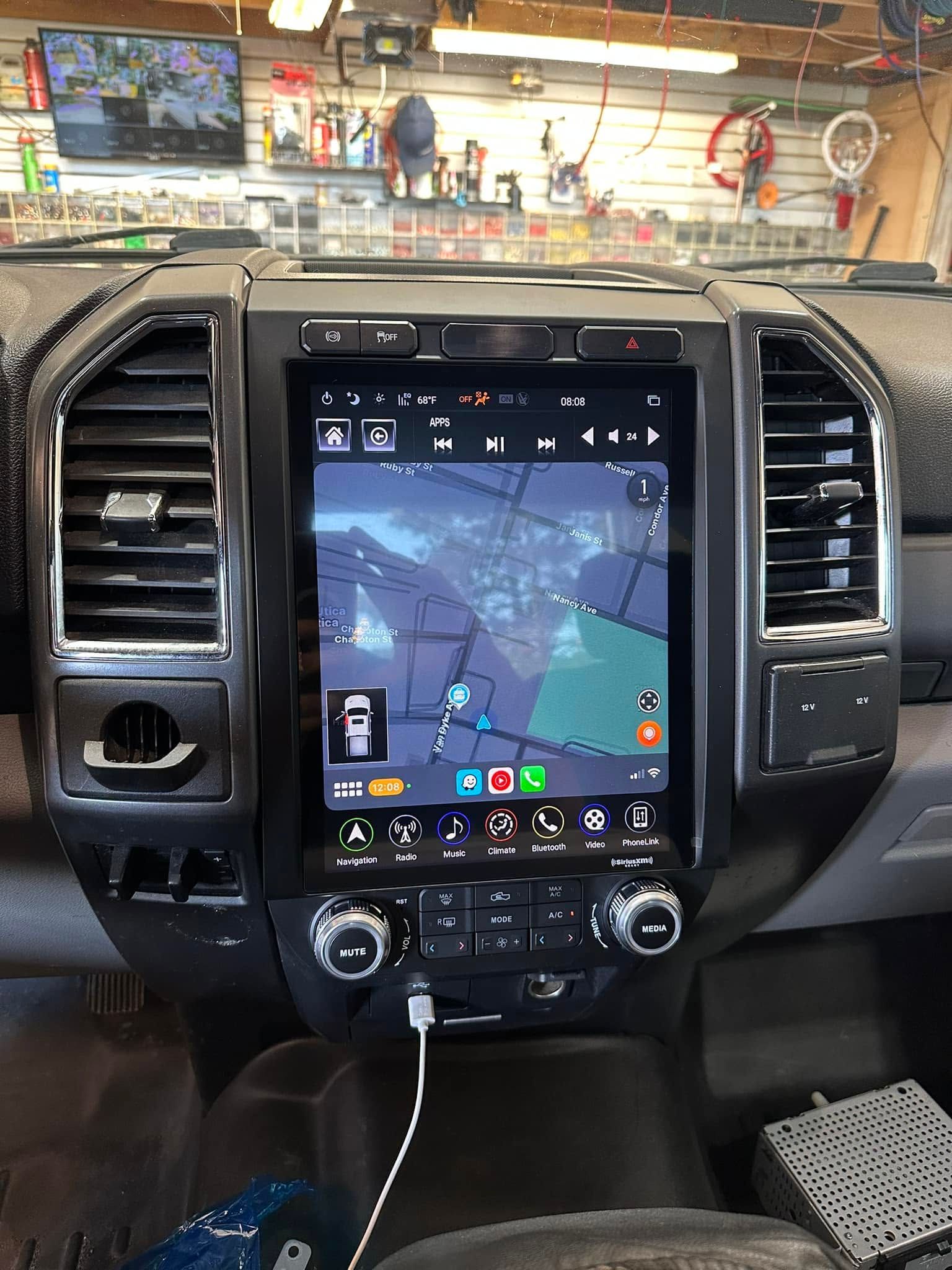 Truck dashboard with a large vertical touchscreen displaying a map/navigation app and climate controls below.