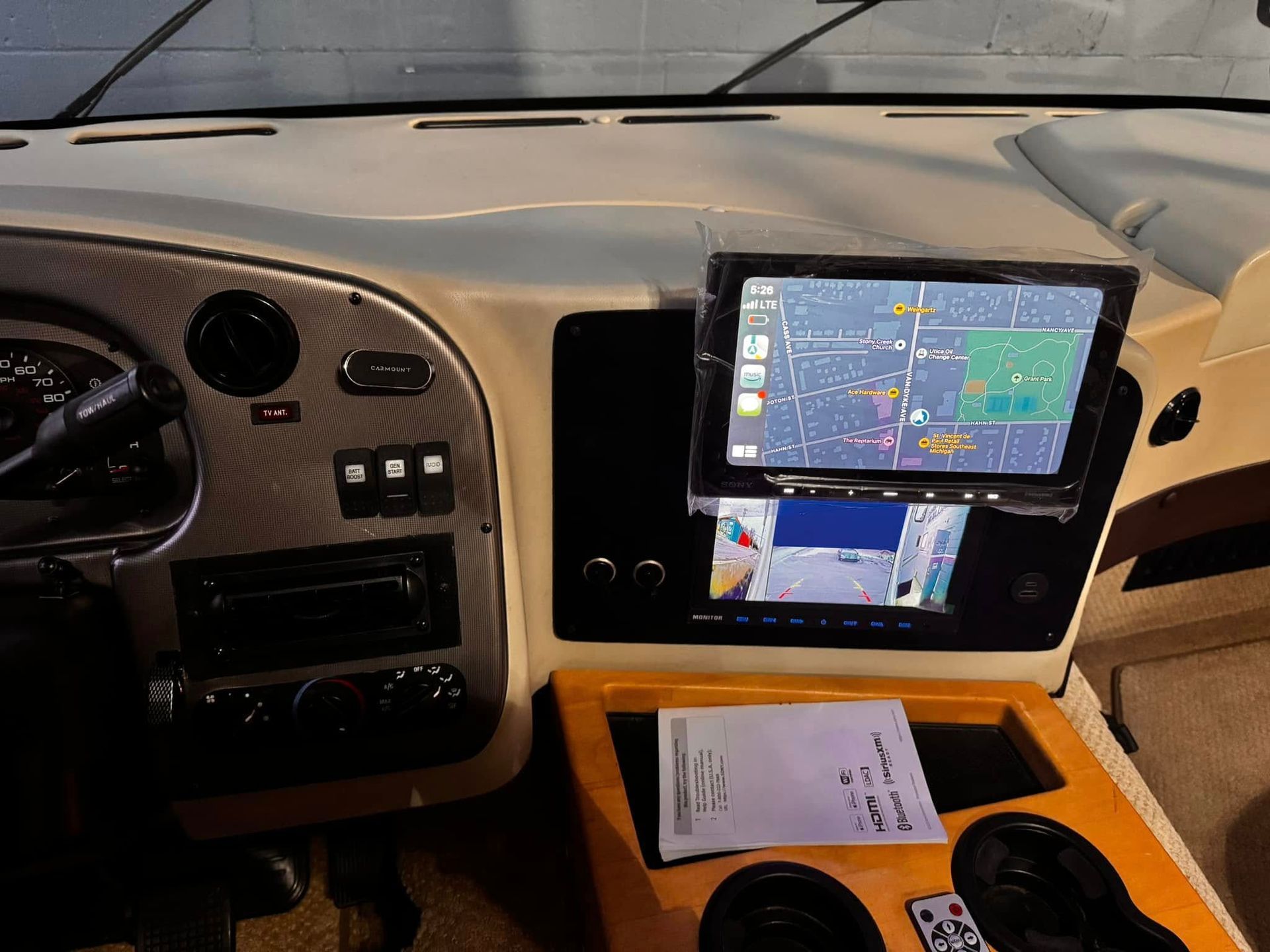 Vehicle dashboard with mounted GPS screen and paper on a wooden center console