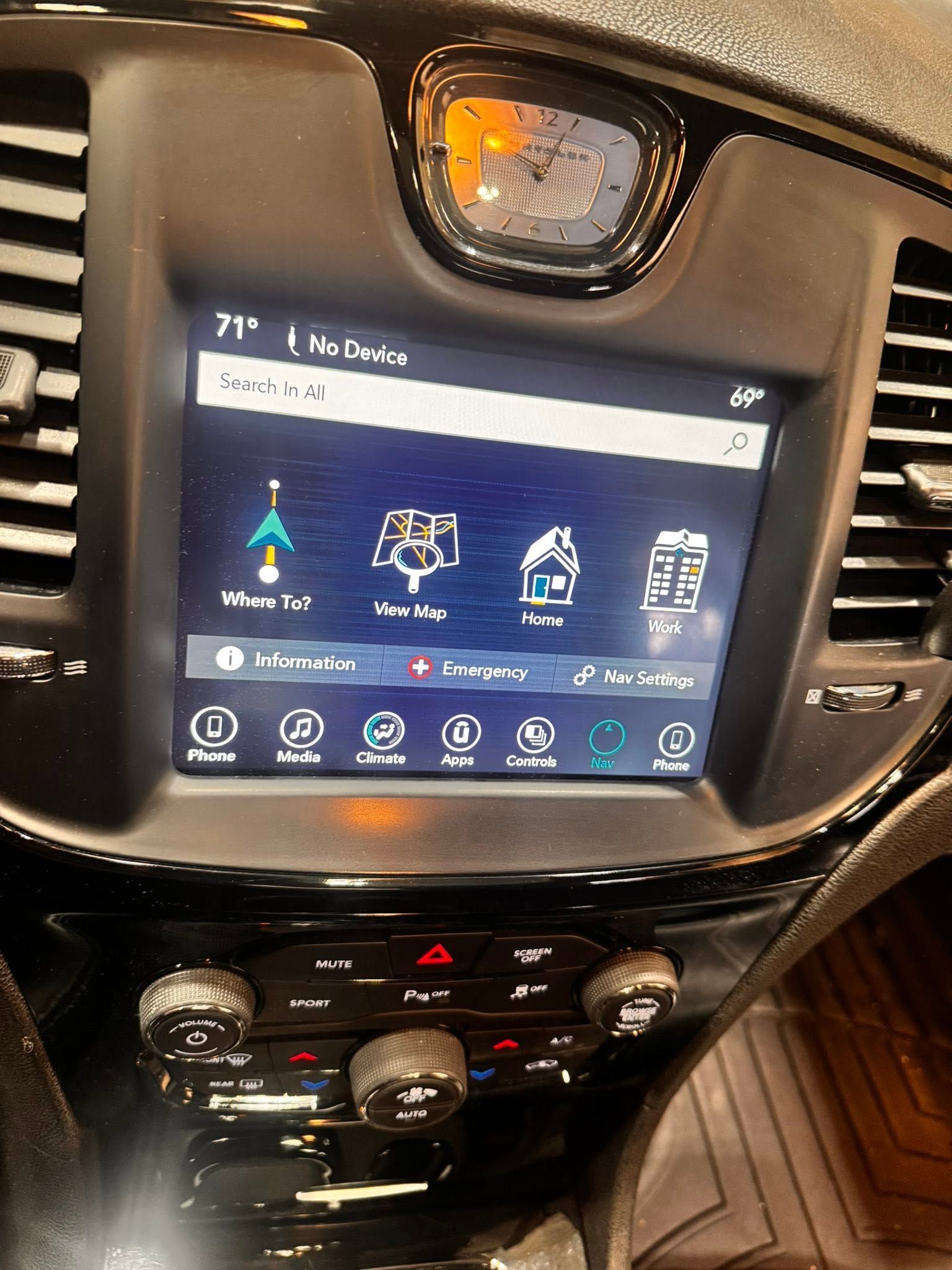 Car dashboard center console with a touchscreen infotainment display and climate controls below.