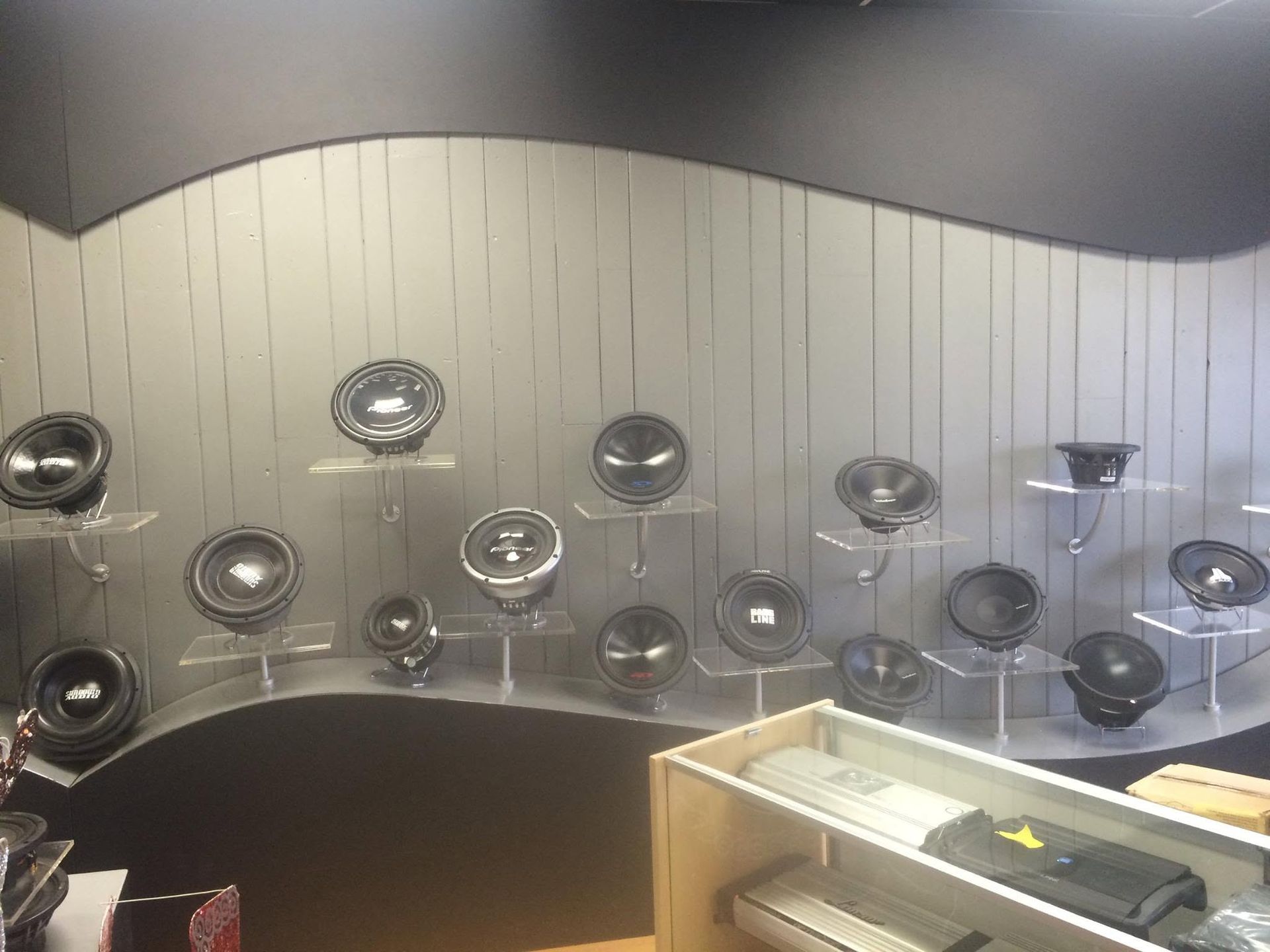 Display of black electric fans on a curved wall in a store or showroom