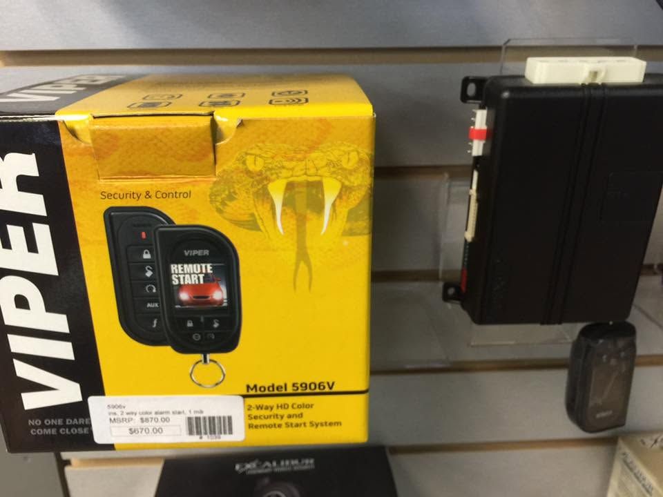 Yellow Viper remote-start system box on a shelf beside a black electronic device and a small cup