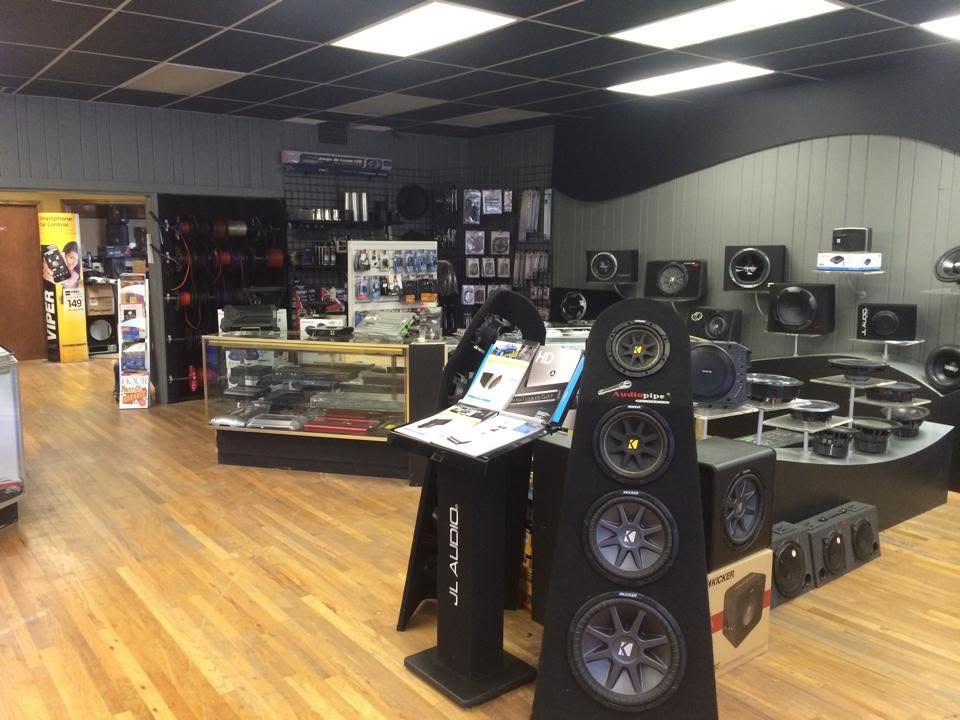Audio and electronics store interior with car speakers, subwoofers, and display counters