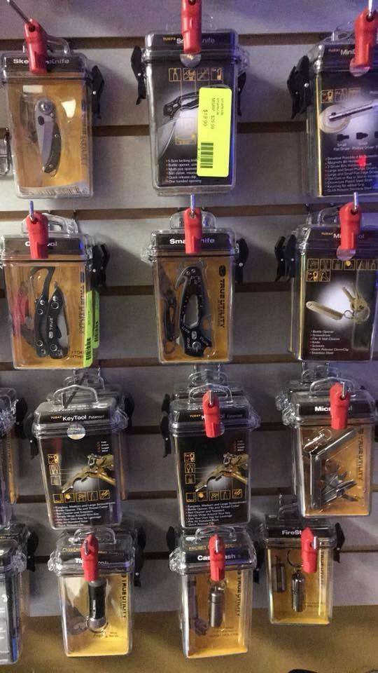 Assorted switch-like devices in clear cases mounted on a wall, each with a red lever and labels.