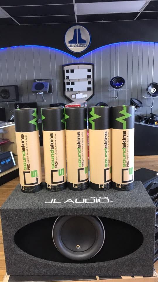 JL Audio speaker with four rechargeable batteries standing on top in a studio display room