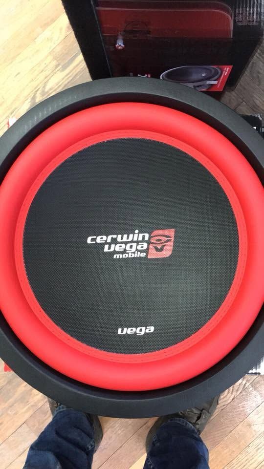 Red and black Centurion Legacy subwoofer on a wooden floor, viewed from above.