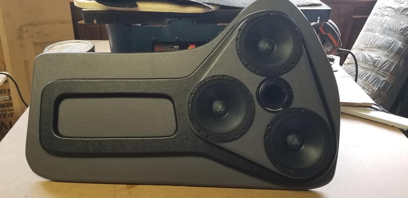 Black gadget with a small display and three circular dials on the right, on a tabletop
