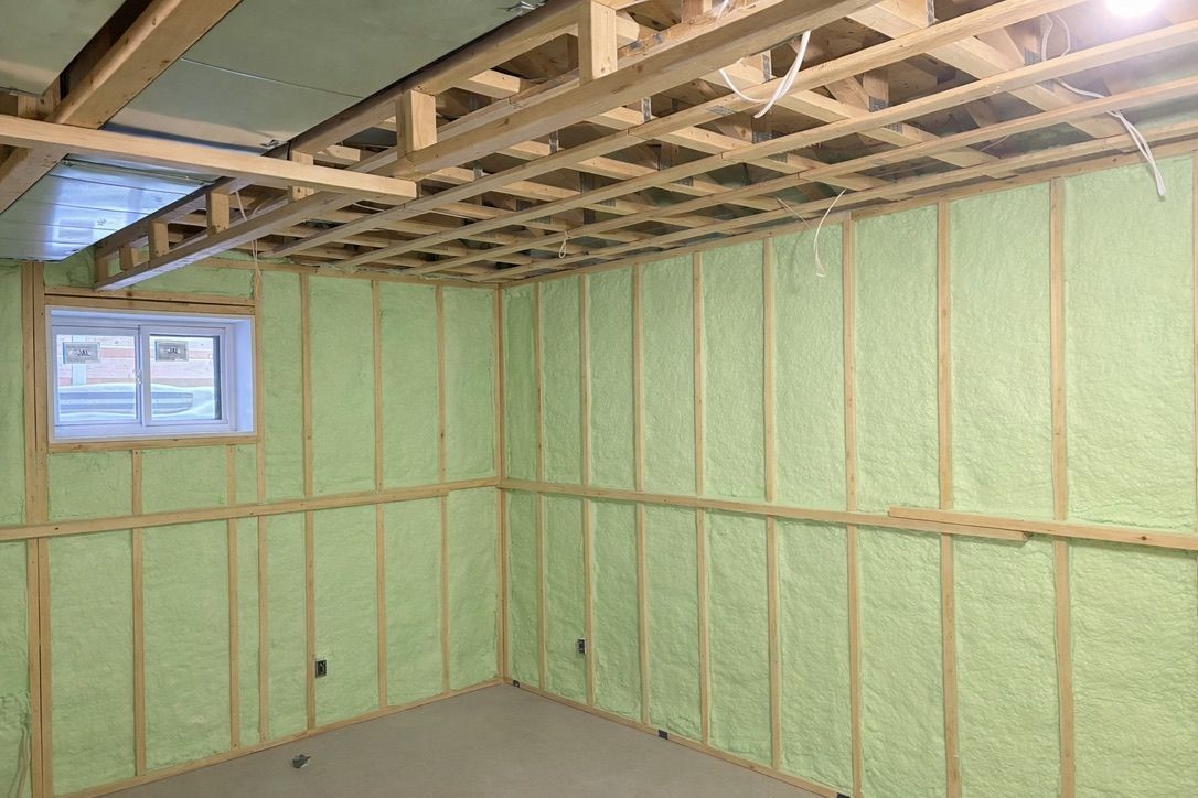 Worker nailing plywood sheathing on a steep roof under construction