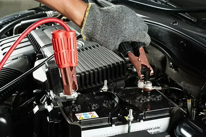 Person Connecting Jumper Cables — Barnco Automotive Repairs in Taminda, NSW