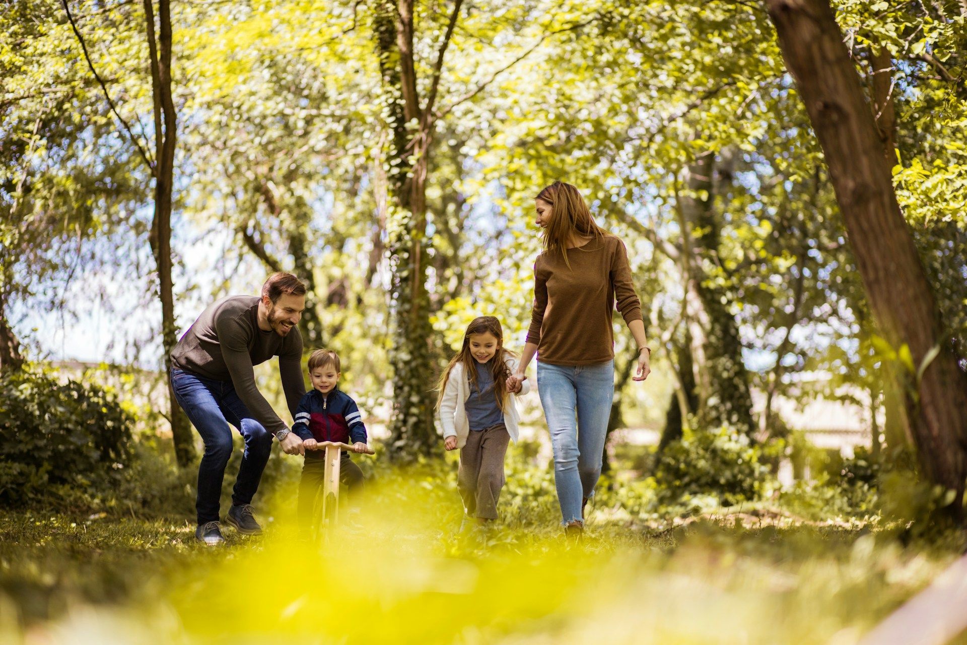 A family is sitting on the grass in front of a house.
