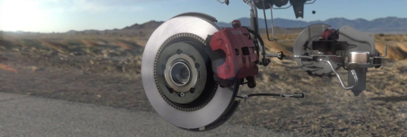 A close up of a brake disc on a car in the desert.