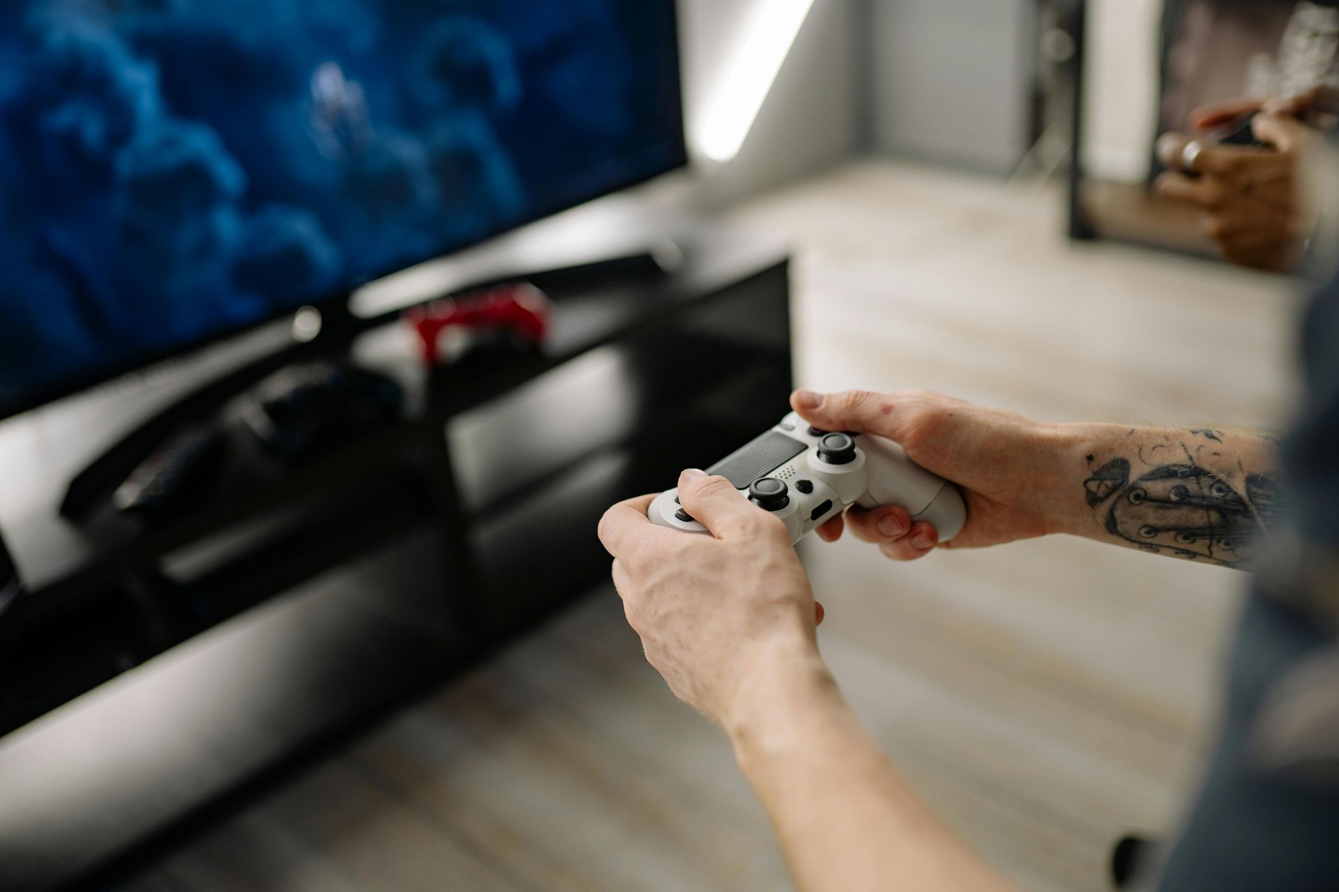 Person holding a game controller in front of a TV in a living room