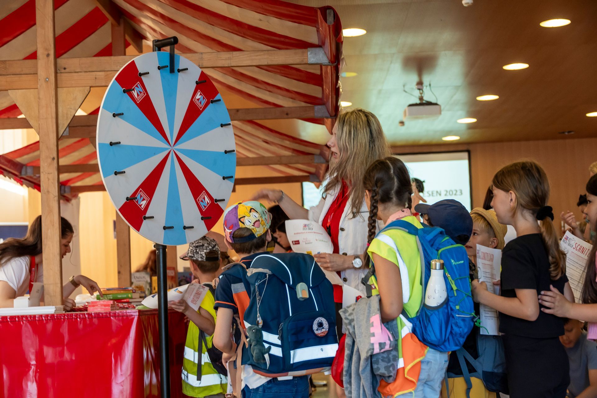Eine Gruppe Kinder steht um ein Glücksrad herum.