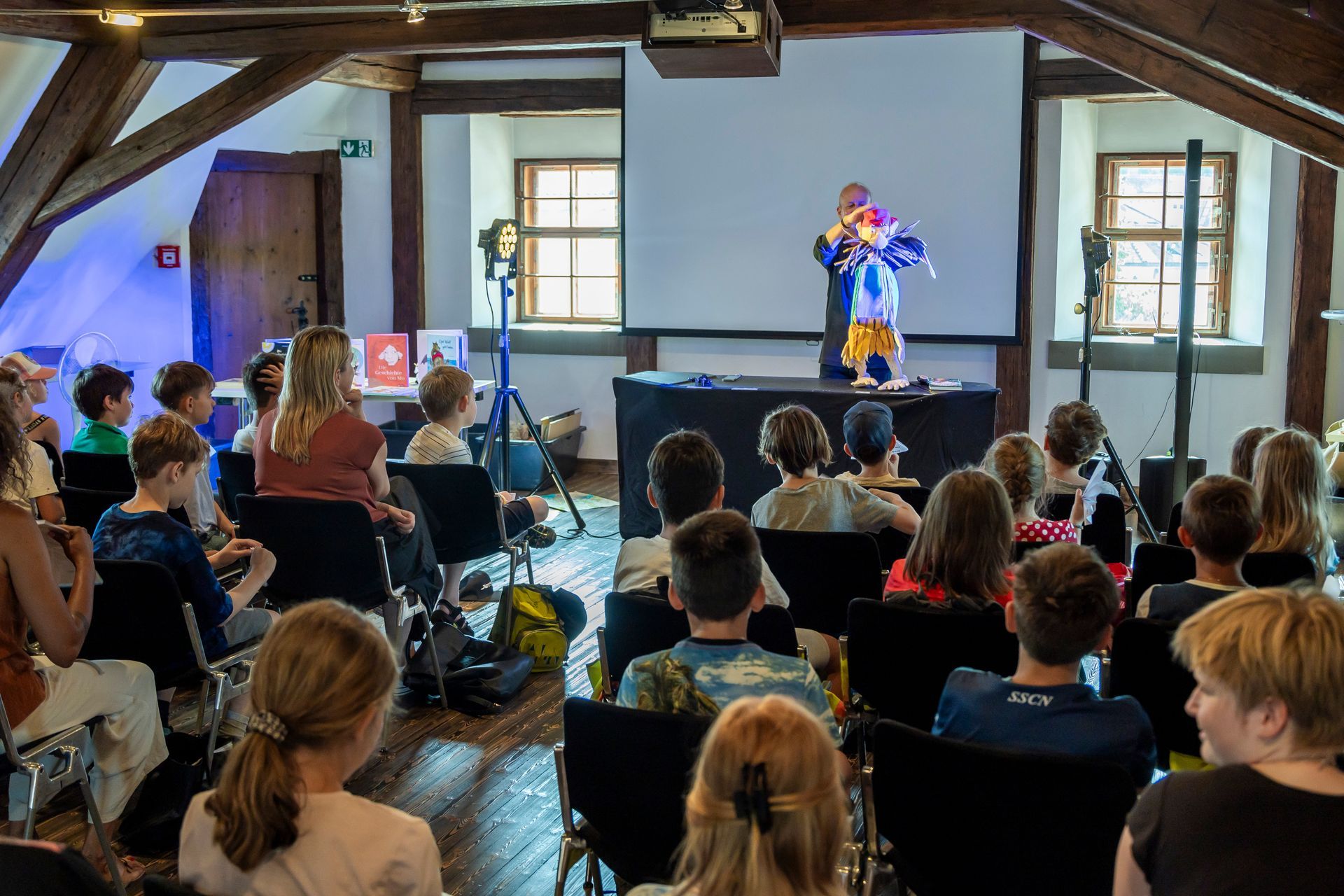Eine Gruppe von Menschen sitzt in einem Raum und sieht sich die Vorstellung eines Clowns an.